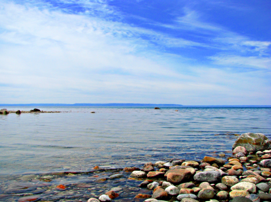 rocky shoreline and blue water and sky